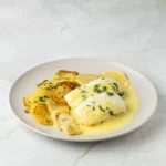 Merluza al limón con patatas panaderas y cebolla